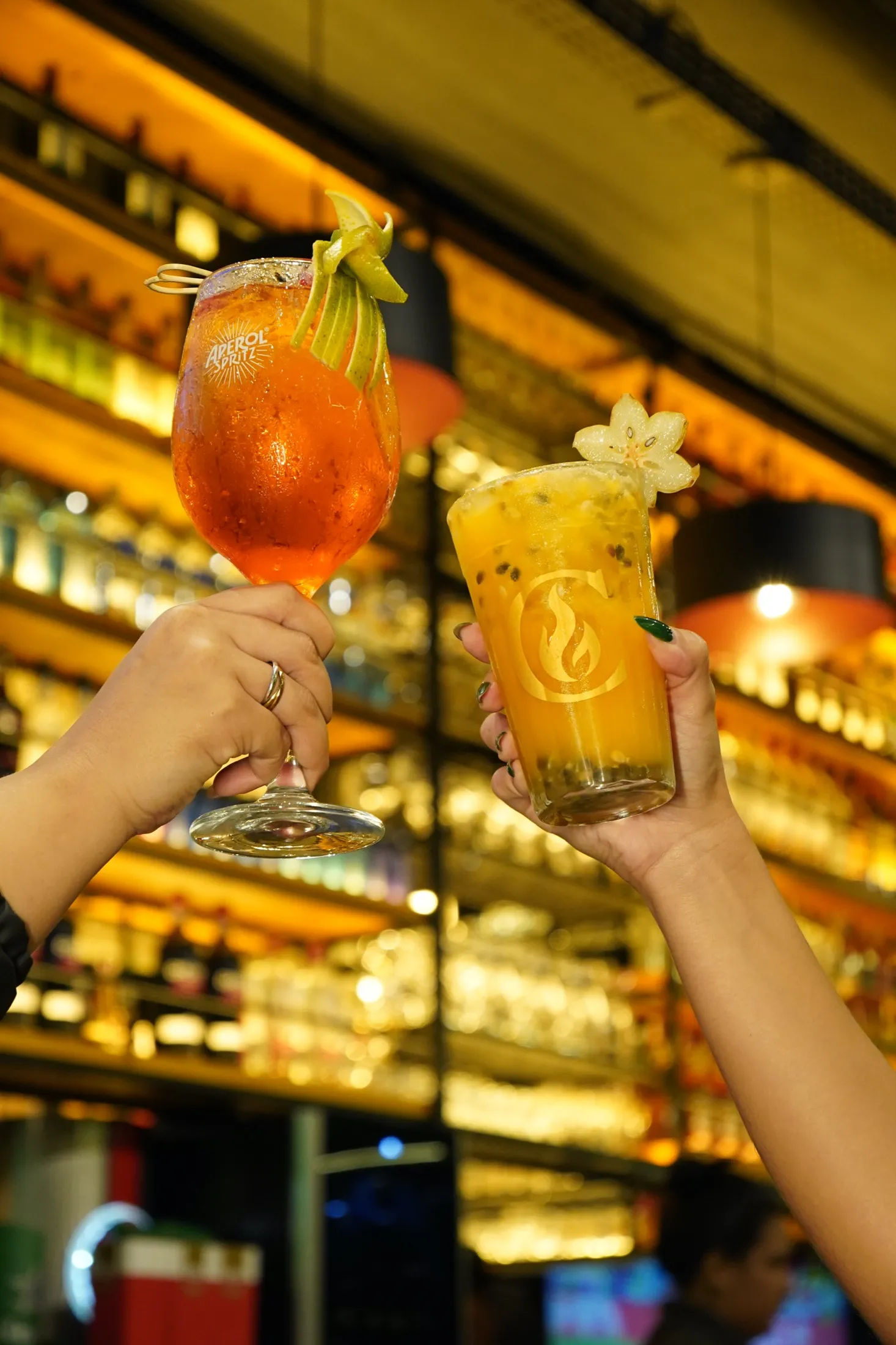 Salão do Chama Rio Choperia e Grill com estante de bebidas retroiluminada em tom âmbar